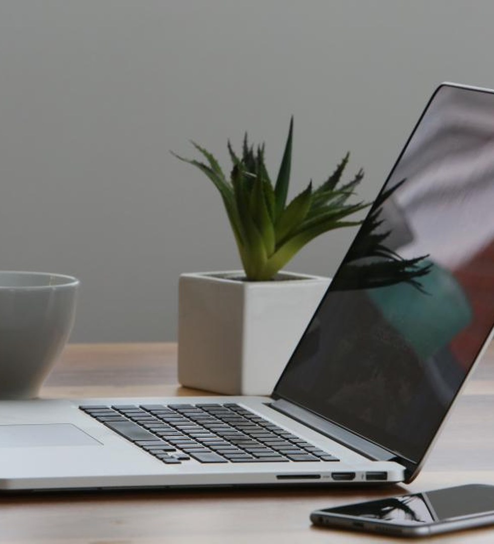 A tidy desk with a laptop and notebook
